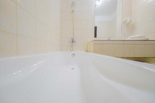 a white bath tub in a bathroom with a mirror at Popasul Caprioarei in Pădureni