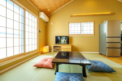 a living room with a table and a refrigerator at Modern Japanese House in Musashi-Kosugi, 3BR, 15 Guests, Family Friendly in Kawasaki