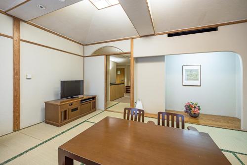 a dining room with a table and a television at Hotel Okura Tokyo Bay in Urayasu