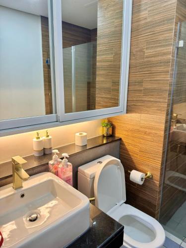 un bagno con lavandino, WC e specchio di Manila Bay Suite a Manila