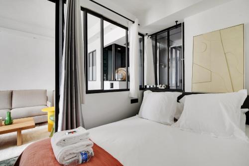 - une chambre avec un grand lit blanc et des fenêtres dans l'établissement Amazing apartment 1BR-4P - Centre Beaubourg, à Paris
