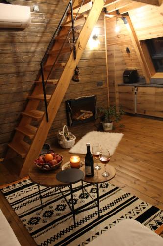 a room with a table with wine glasses and a fireplace at Dakota forest retreat in Tsigov Chark