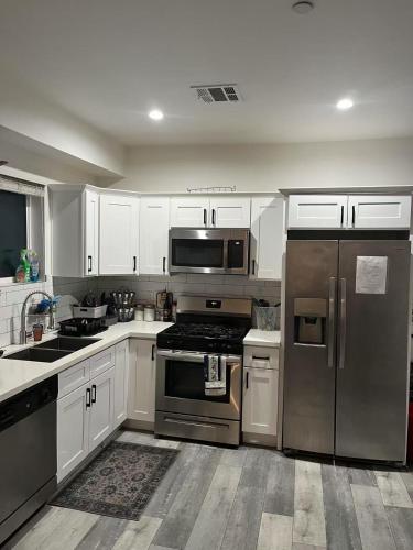 a kitchen with stainless steel appliances and white cabinets at Modern Hostel address changed in Los Angeles