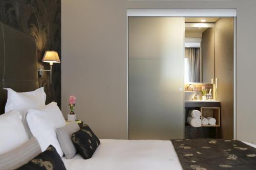 Habitación de hotel con cama y espejo en The Y Hotel en Athens