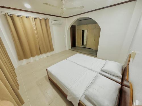 a bedroom with a white bed in a room at Bluewaves Hostel & Villa Panagsama by Hiverooms in Moalboal