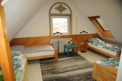 ハノーファーにあるハノーヴァー メッセ ジマーのベッド2台と窓が備わる屋根裏部屋です。