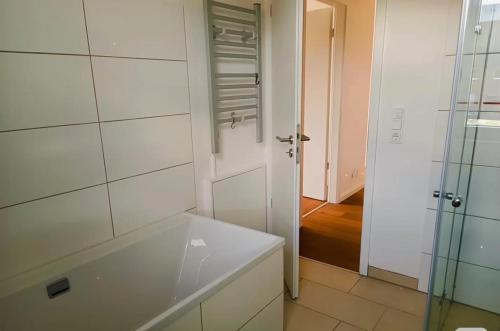 a bathroom with a tub and a glass shower at Messe Düsseldorf und Essen Flughafen in Ratingen