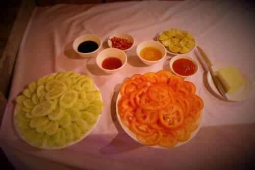 una tavola con piatti di alimenti e ciotole di condimenti di Sapa Dragon Hotel a Sa Pa