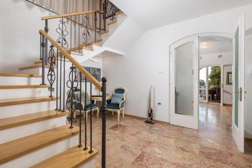 a staircase in a home with a table and a chair at Villa Magnolia Umag in Umag