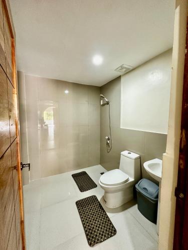 a small bathroom with a toilet and a sink at Bluewaves Hostel & Villa Panagsama by Hiverooms in Moalboal