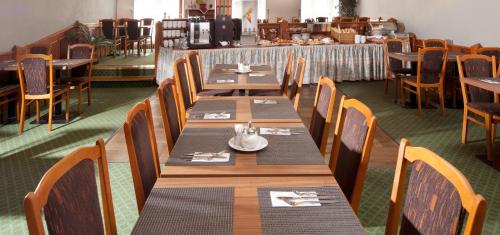 a dining room with wooden tables and chairs at Hotel Concertino Zlatá Husa in Jindrichuv Hradec