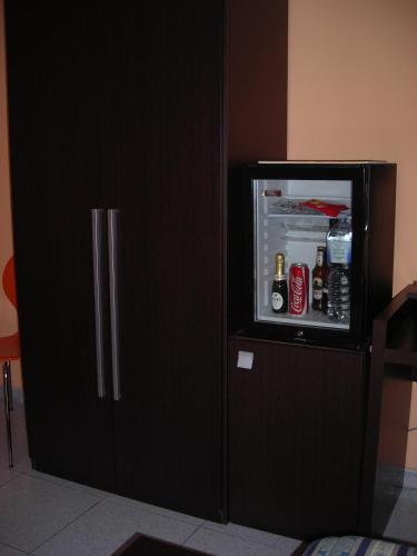una nevera negra con la puerta abierta con bebidas en ella en B&B CasAnsaldo, en Giarre