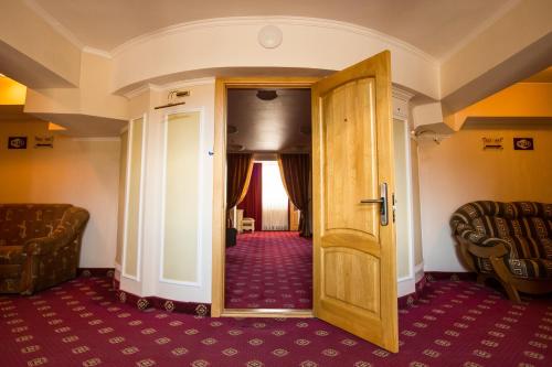 a room with a door and a couch and a chair at Bukovyna Hotel in Chernivtsi
