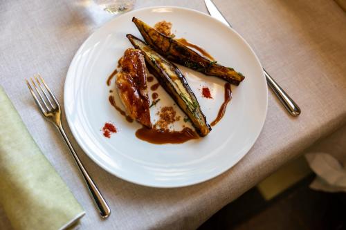 a white plate of food with asparagus on a table at Castel Pergine in Pergine Valsugana