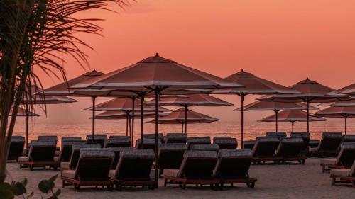 a group of chairs and umbrellas on a beach at Jumeirah Marsa Al Arab Dubai in Dubai
