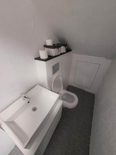 a white bathroom with a sink and a toilet at Vila Vati - Arena Pitesti in Piteşti