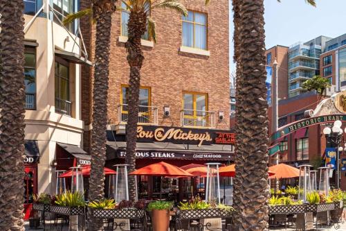 a restaurant with tables and umbrellas in front of a building at Hilton San Diego Gaslamp Quarter in San Diego