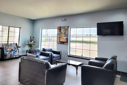 a waiting room with leather chairs and a flat screen tv at Days Inn by Wyndham Kemah in Kemah