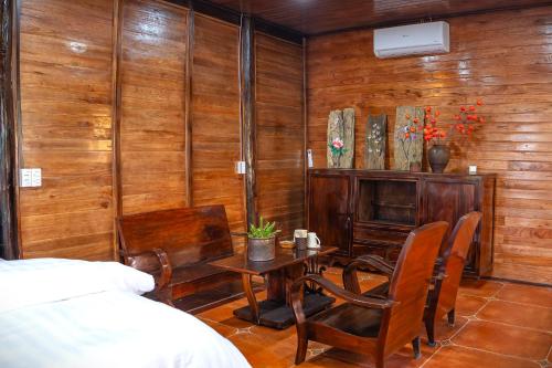 a bedroom with a table and chairs and a bed at Mế farmstay in Cao Bằng