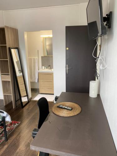 a room with a table with a television on top of it at Superbe Chambre parentale avec salle de bains privée et WC privés, wifi, cuisine in Vandoeuvre-lès-Nancy
