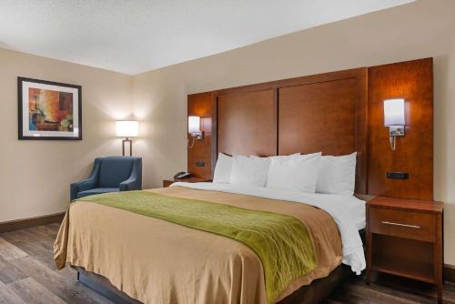 a hotel room with a large bed and a blue chair at City Express by Marriott Yulee in Yulee