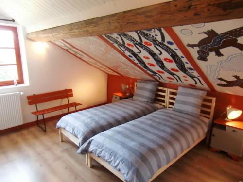 a bedroom with a bed with a painting on the wall at Chambre&Table d'hotes PtitMonde in Ban-sur-Meurthe-Clefcy