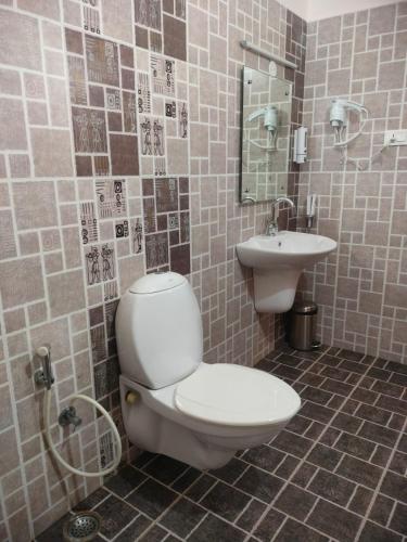 a bathroom with a toilet and a sink at Blissfull Meadows in Ooty