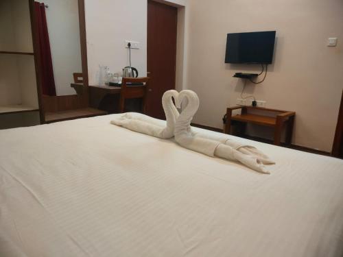 a white swan made out of towels on a bed at Blissfull Meadows in Ooty