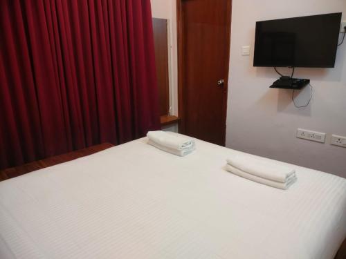 a bedroom with a bed with two towels on it at Blissfull Meadows in Ooty