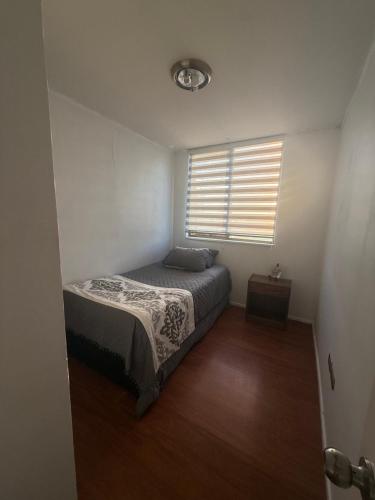 a small bedroom with a bed and a window at Vista Laguna Redonda in Concepción