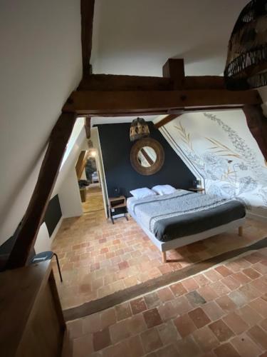 an attic room with a bed and a bench at Domaine de la Maroutière in Saint-Fort