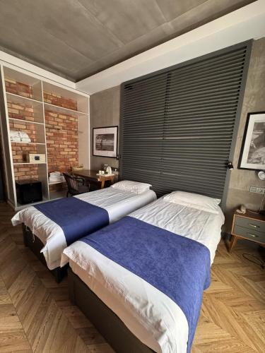 two beds in a bedroom with a large window at Bugu Hotel Bishkek in Bishkek