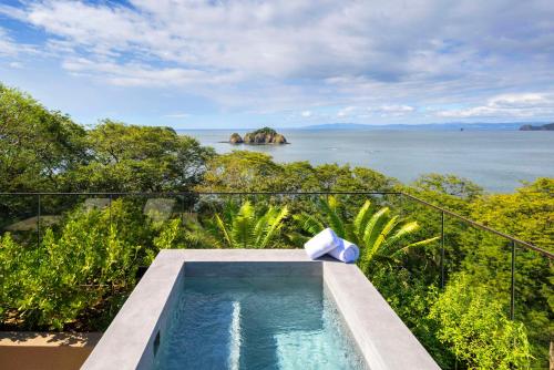 an outdoor swimming pool with a view of the ocean at Waldorf Astoria Costa Rica Punta Cacique in Playa Hermosa