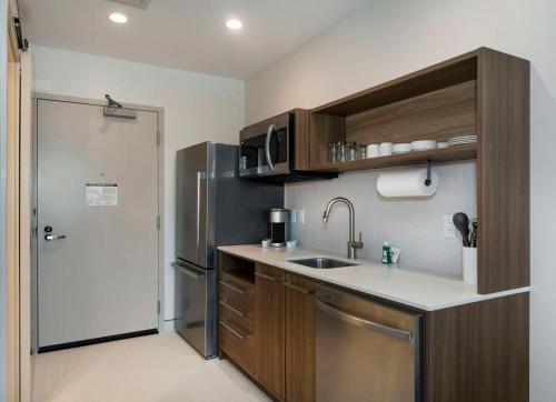 a small kitchen with a sink and a refrigerator at Home2 Suites By Hilton Lumberton in Lumberton