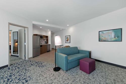 a living room with a blue chair and a purple stool at Home2 Suites By Hilton Lumberton in Lumberton
