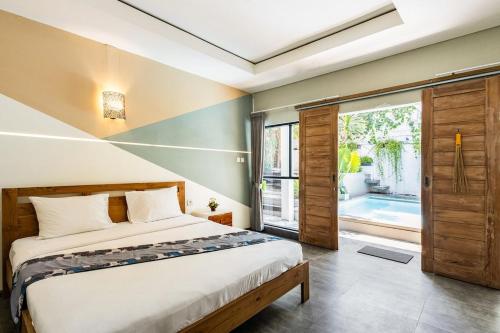 a bedroom with a bed and a large window at Villa The Jambu in Tumbak Bayuh