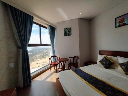 a hotel room with a bed and a large window at Chambay Bliss Retreat Mũi Né in Phan Thiet