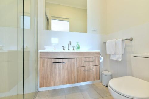 a bathroom with a toilet and a sink and a shower at Beach Escape at Caves Beach Villas in Caves Beach
