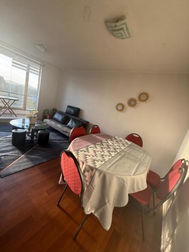 a living room with a table and chairs and a couch at Vista Laguna Redonda in Concepción