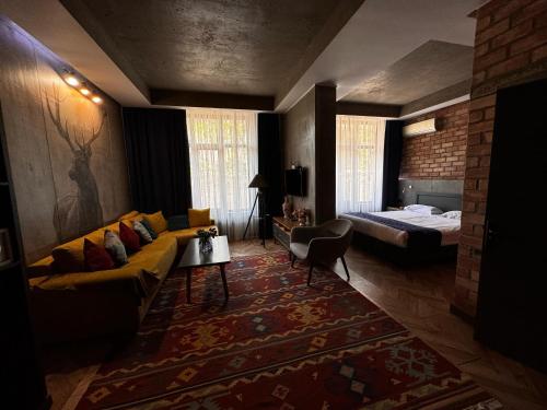 a living room with a couch and a bed in a room at Bugu Hotel Bishkek in Bishkek