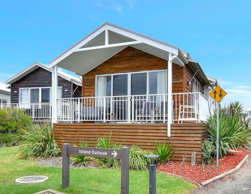 a house with a sign in front of it at Sandy Isles at Caves Beach Villas in Caves Beach