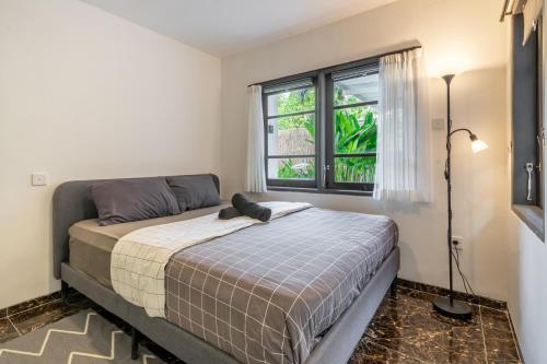 a bedroom with a bed and a window at Sahadewa 46 - Dreamland Golf Complex 4 Bedroom in Uluwatu