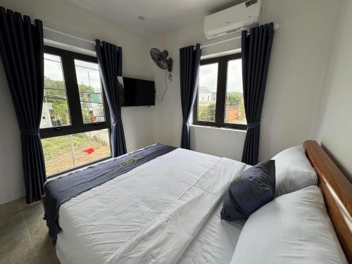 a bedroom with a bed and two windows at Thái Bảo 4 Hotel in Quang Ngai