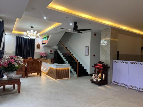 a living room with a chandelier and a staircase at Thái Bảo 4 Hotel in Quang Ngai