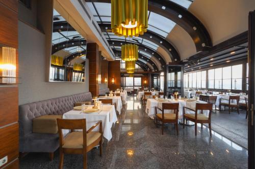 a dining room with tables and chairs and chandeliers at Tugcan Hotel in Gaziantep