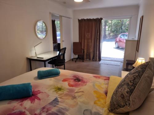 a bedroom with a bed with a flower pattern on it at Mountain Creek Retreat in Mountain Creek
