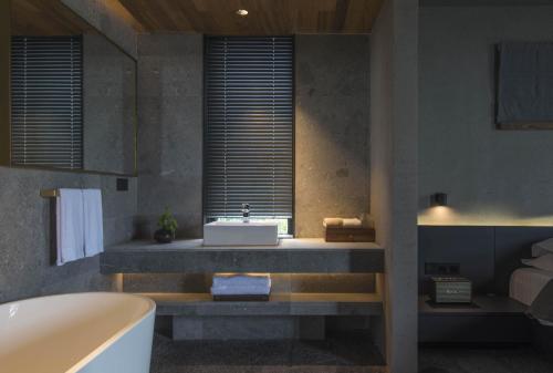a bathroom with a tub and a sink at Yakamoz Erhai Hotel in Dali