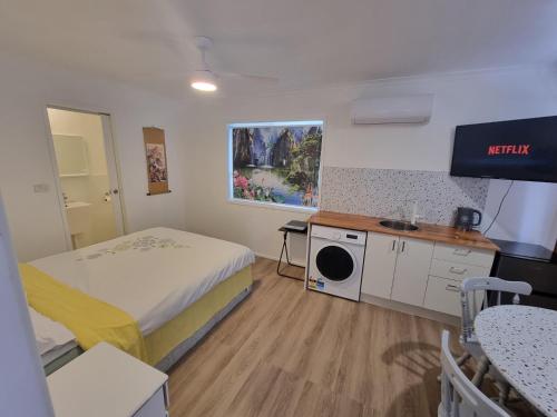 a small room with a bed and a table and a kitchen at Mountain Creek Retreat in Mountain Creek