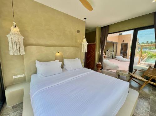 a bedroom with a large white bed and a patio at Villa Terracotta 2 - 3 Bedrooms - Lamai Coconut Grove in Ban Lamai