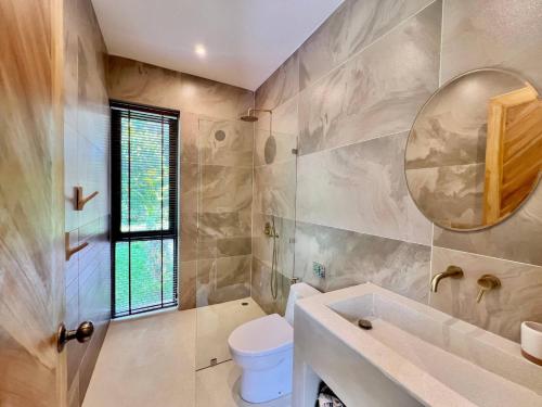 a bathroom with a toilet and a sink and a mirror at Villa Terracotta 2 - 3 Bedrooms - Lamai Coconut Grove in Ban Lamai